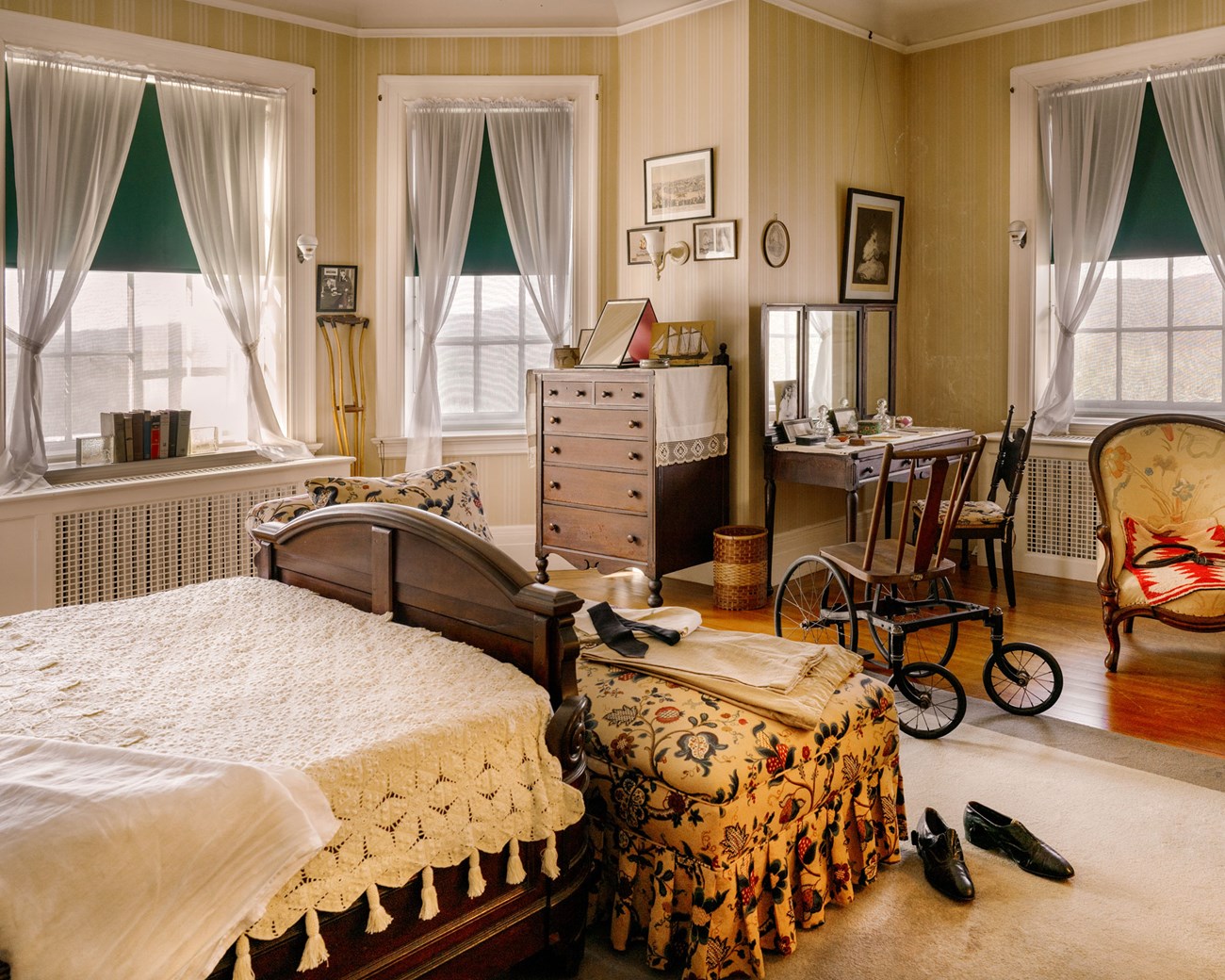 A bedroom with bay window. FDR's wheelchair is at the foot of the bed.