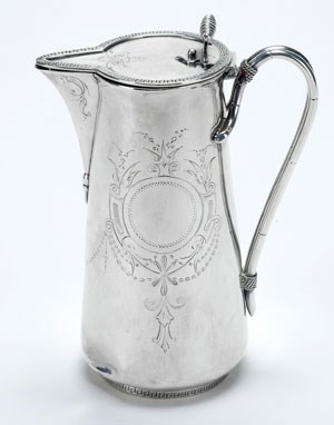 A silver pitcher with engraved decoration of swags and garlands.