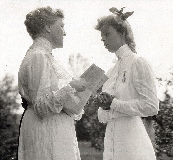 Sara and Eleanor standing in conversation outdoors.