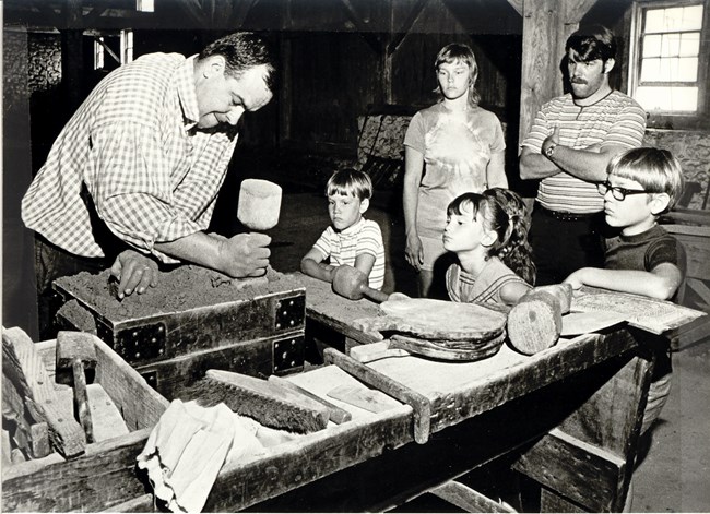 Family views sand moulding demonstration inside Cast House.