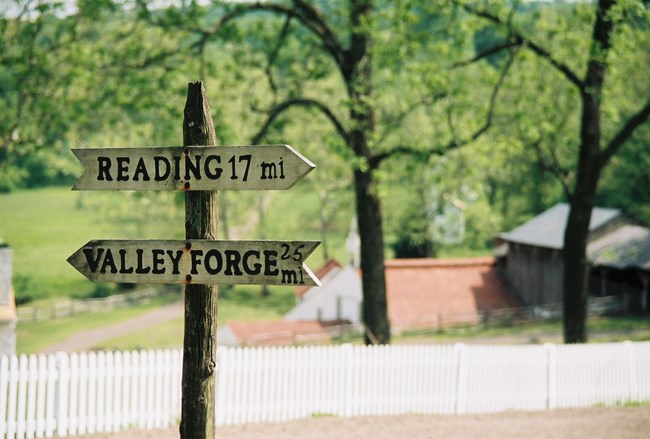 Wooden road sign giving directions and mileage to nearby Reading and Valley Forge.