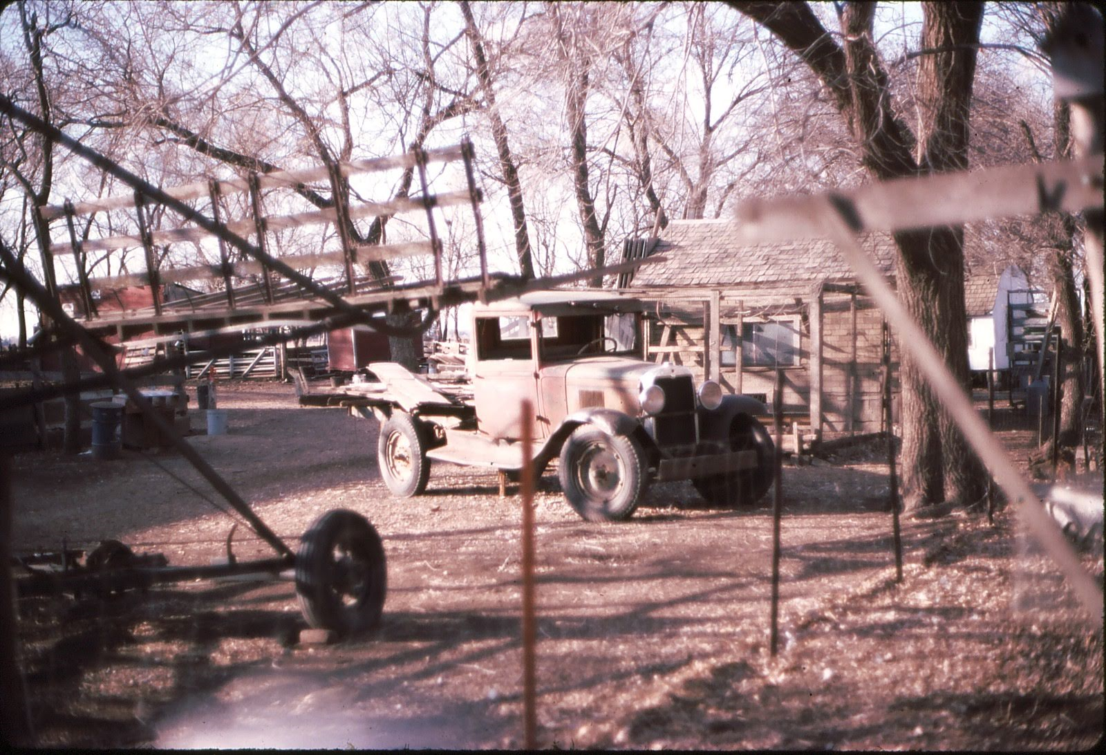 A truck parked on a homestead near farm equipment