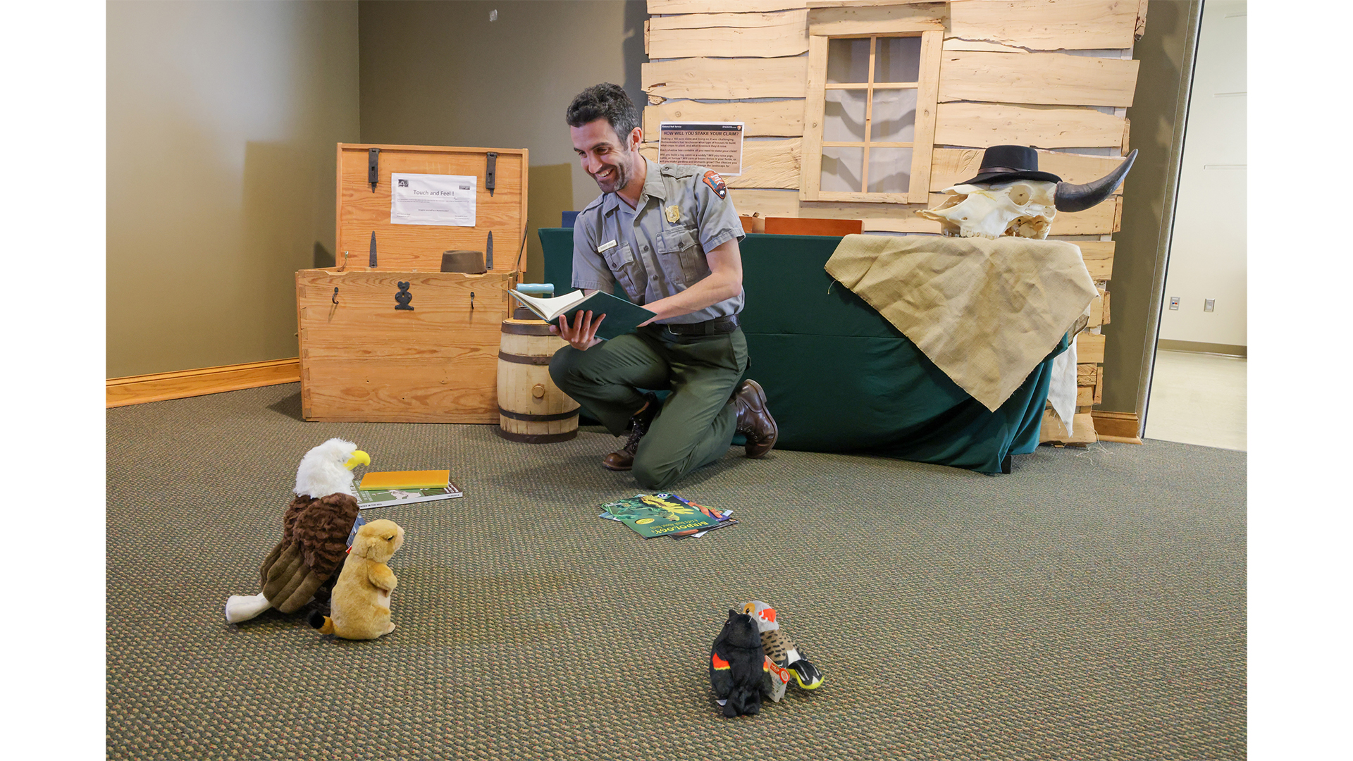 Ranger practices reading a book to stuffed animals