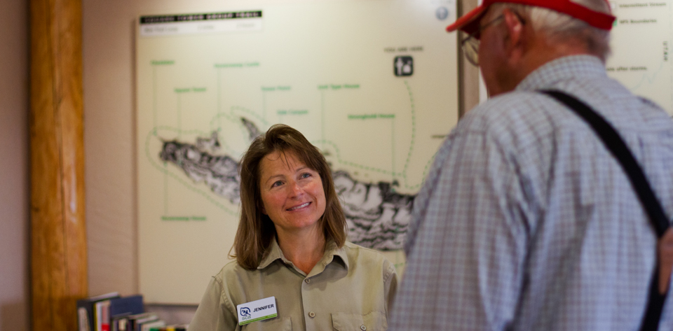 two people speak at a visitor center desk