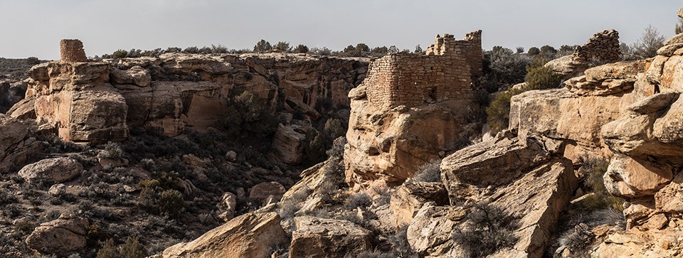several stone structures stand on a canyon rim