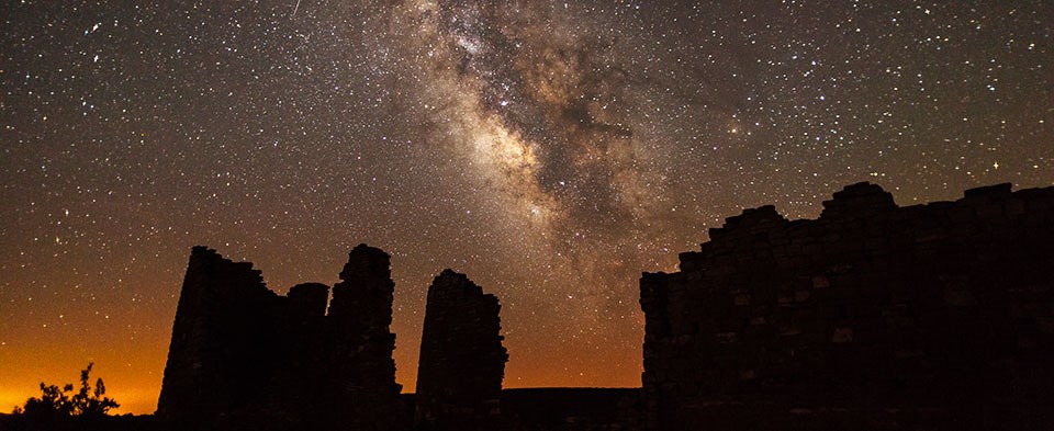 The Milky Way arcs above a silhouetted rock structure