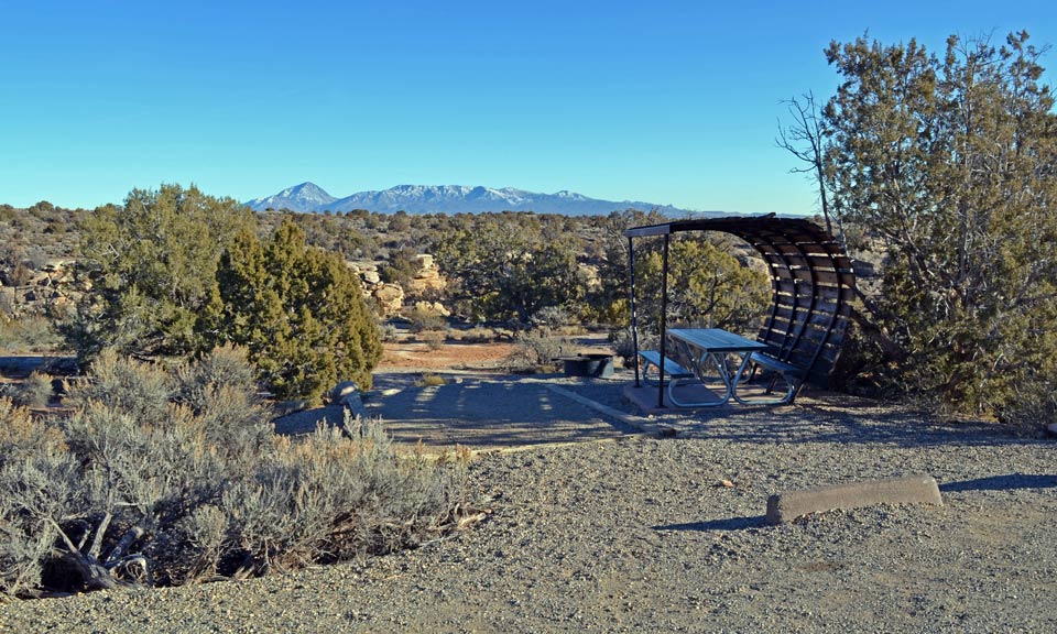 campsite with tent pad and picnic table covered by wooden shade structure