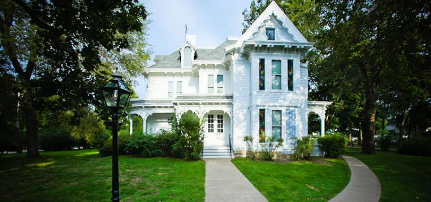 The white Truman Home, with green grass