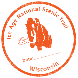 Graphic of an orange national parks passport stamp. The stamp is round with "Ice Age National Scenic Trail Wisconsin" written around the inside, with an illustration of a wholly mammoth in the middle.