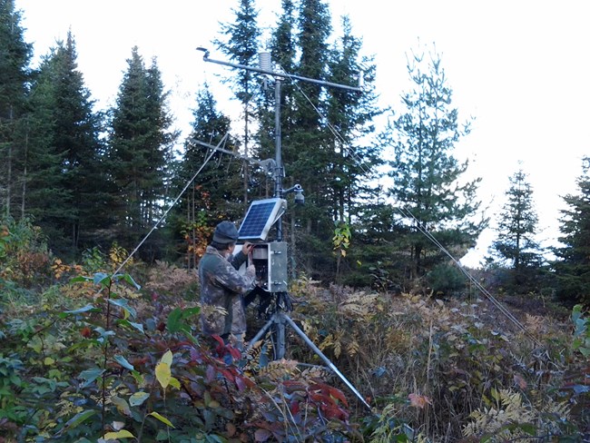 Scientist checks instruments at a remote weather station