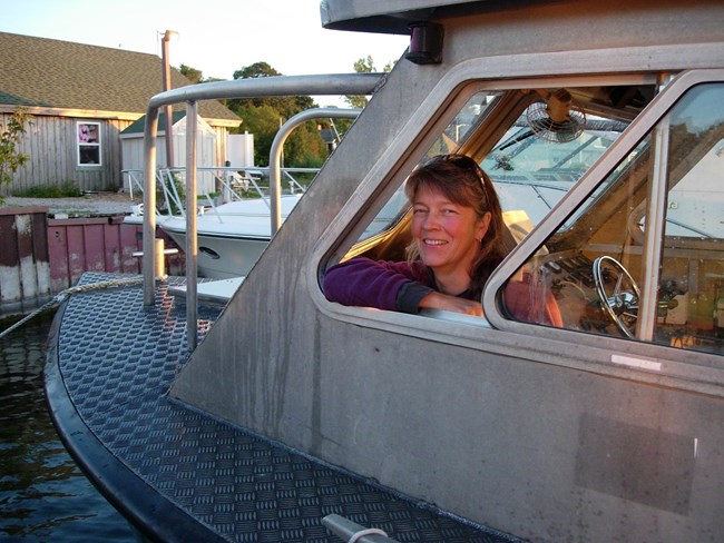 A woman smiles from the window of a boat