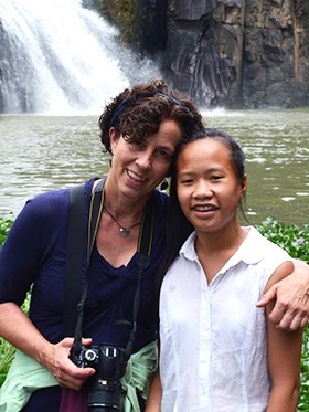 Sara with her daughter standing in front of a waterfall