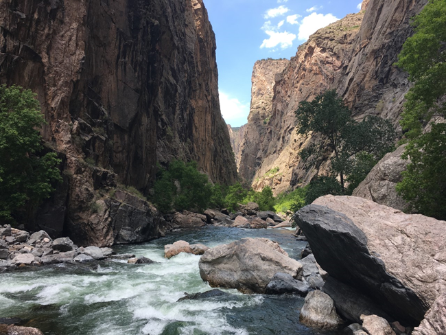Gunnison River rushes through steep, narrow canyon walls at Black Canyon's tightest point.