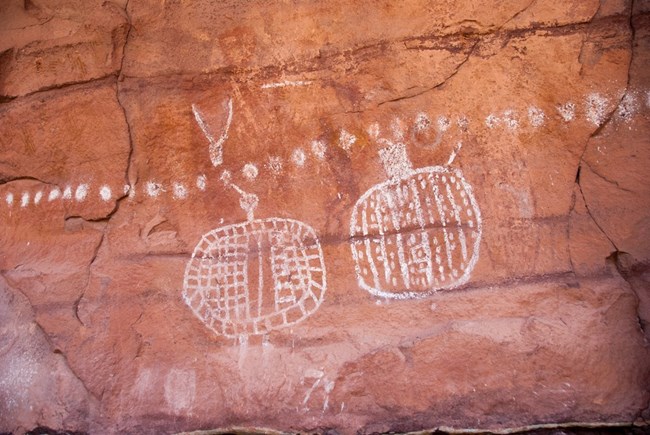 White pictographs on red sandstone wall at Peekaboo in Canyonlands National Park.
