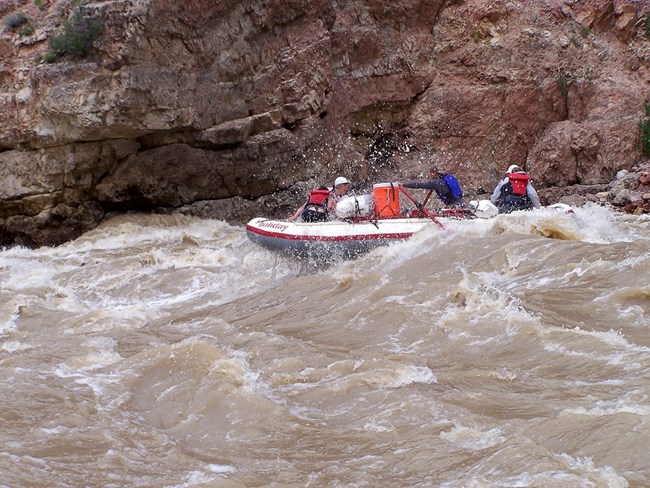 Raft navigating whitewater rapids in Split Mountain Canyon