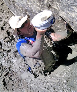 Man in mud with scientific equipment