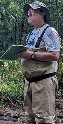 Man in waders holding a clipboard