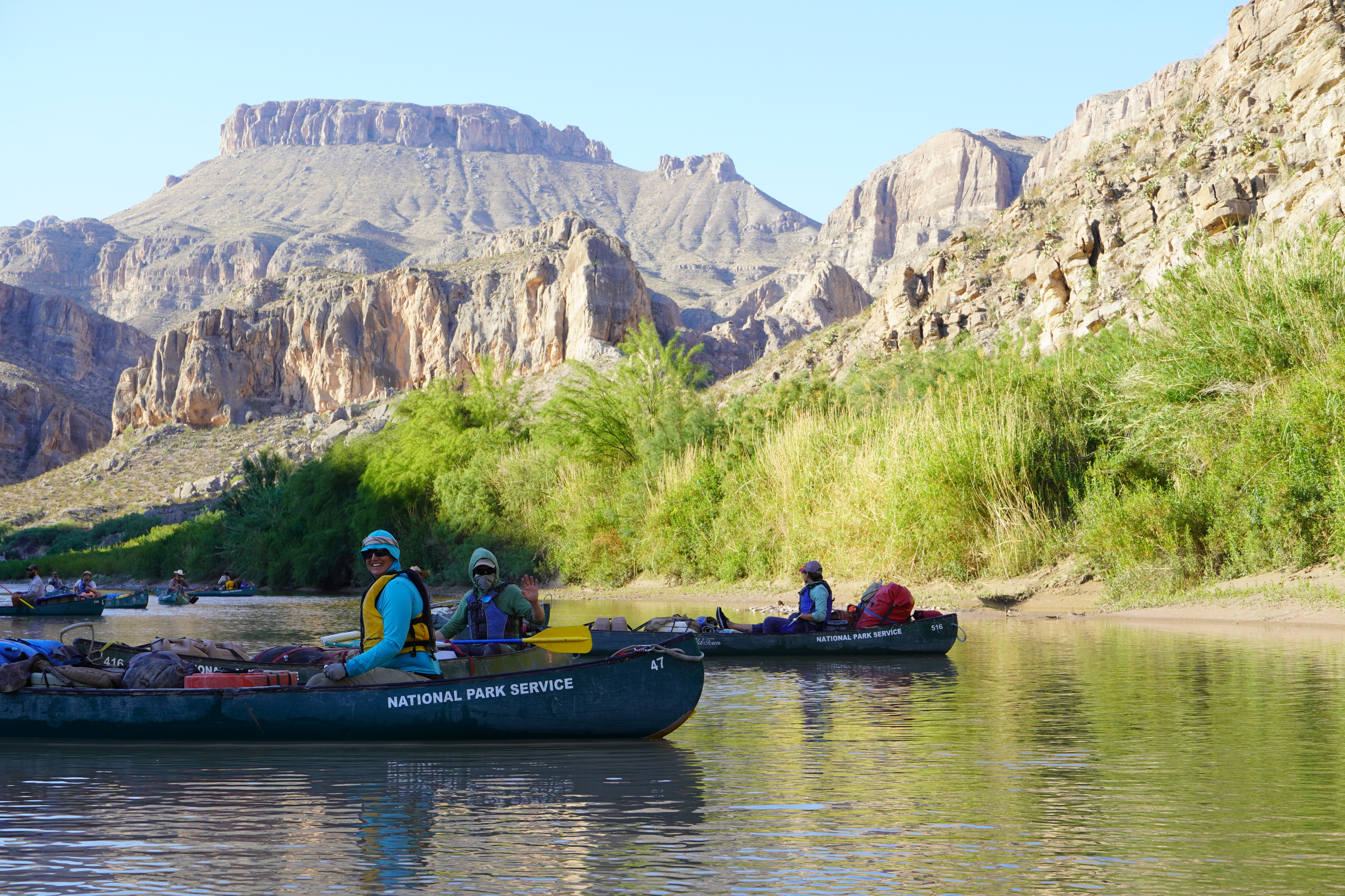 People sit in rafts marked National Park Service.