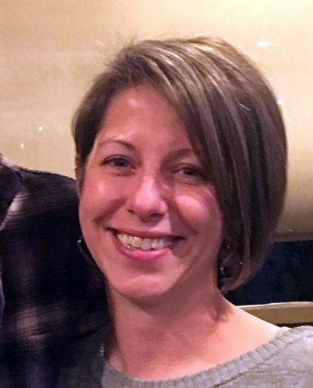 Brown-haired woman smiles into camera