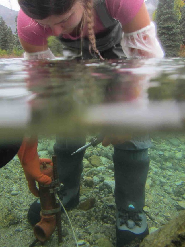 A technician downloads data from an instrument under the water.