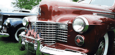 Closeup of red car grill with small American flags