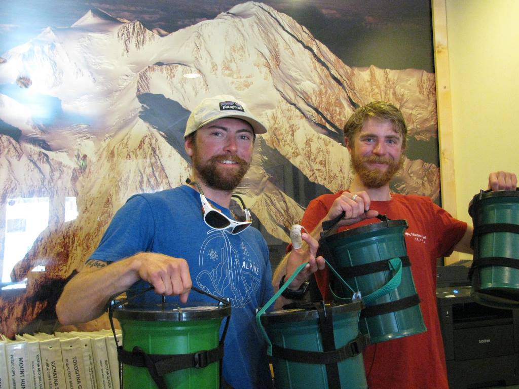 Two climbers holding Clean Mountain Cans