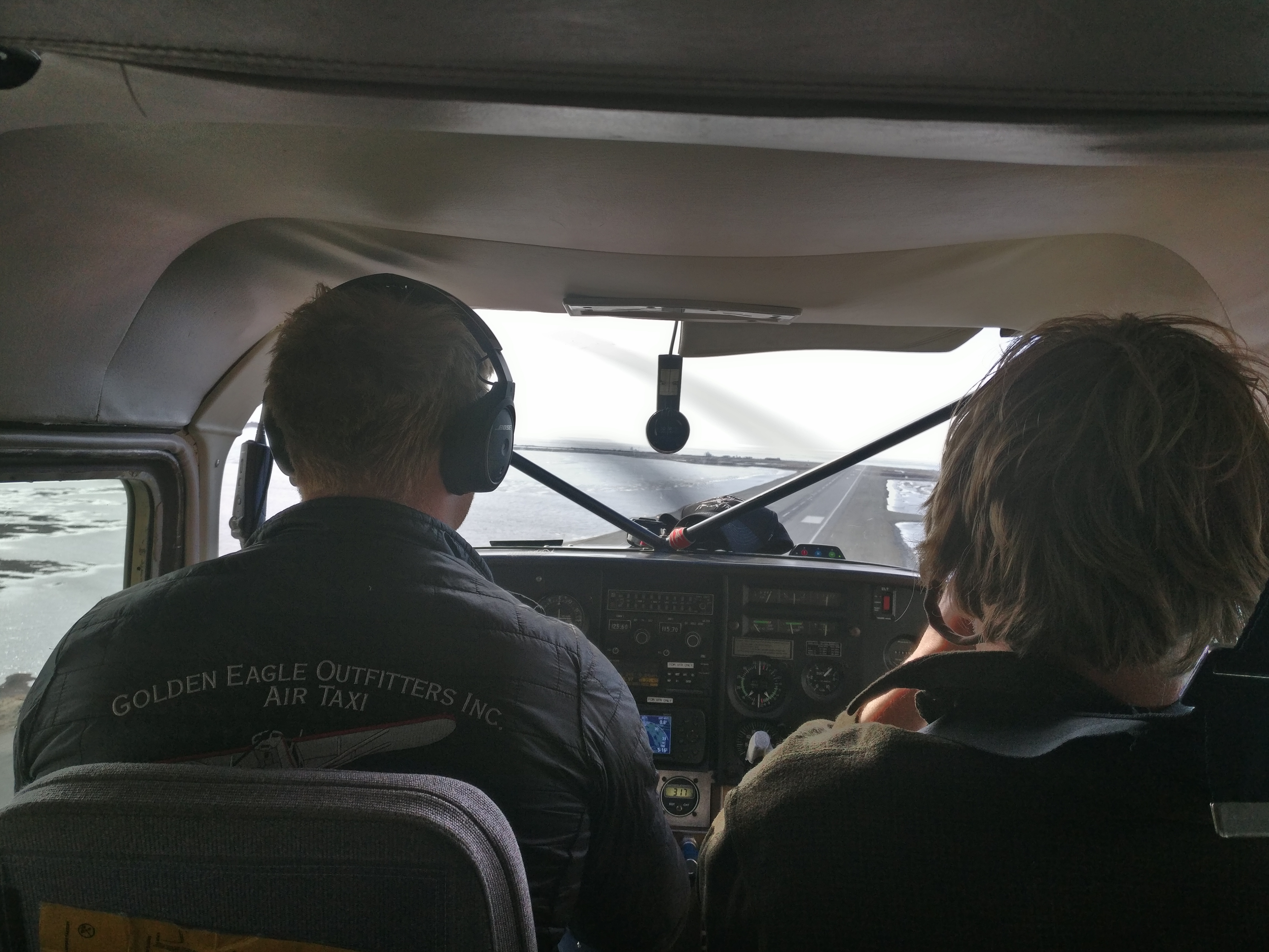 A pilot and passenger in a small plane make their final approach to the runway of the airport in Kotzebue.  