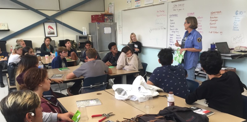 Volunteer talking to students about native plant restoration