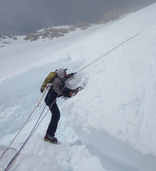 A climber attempts to climb over the lip of a bergschrund