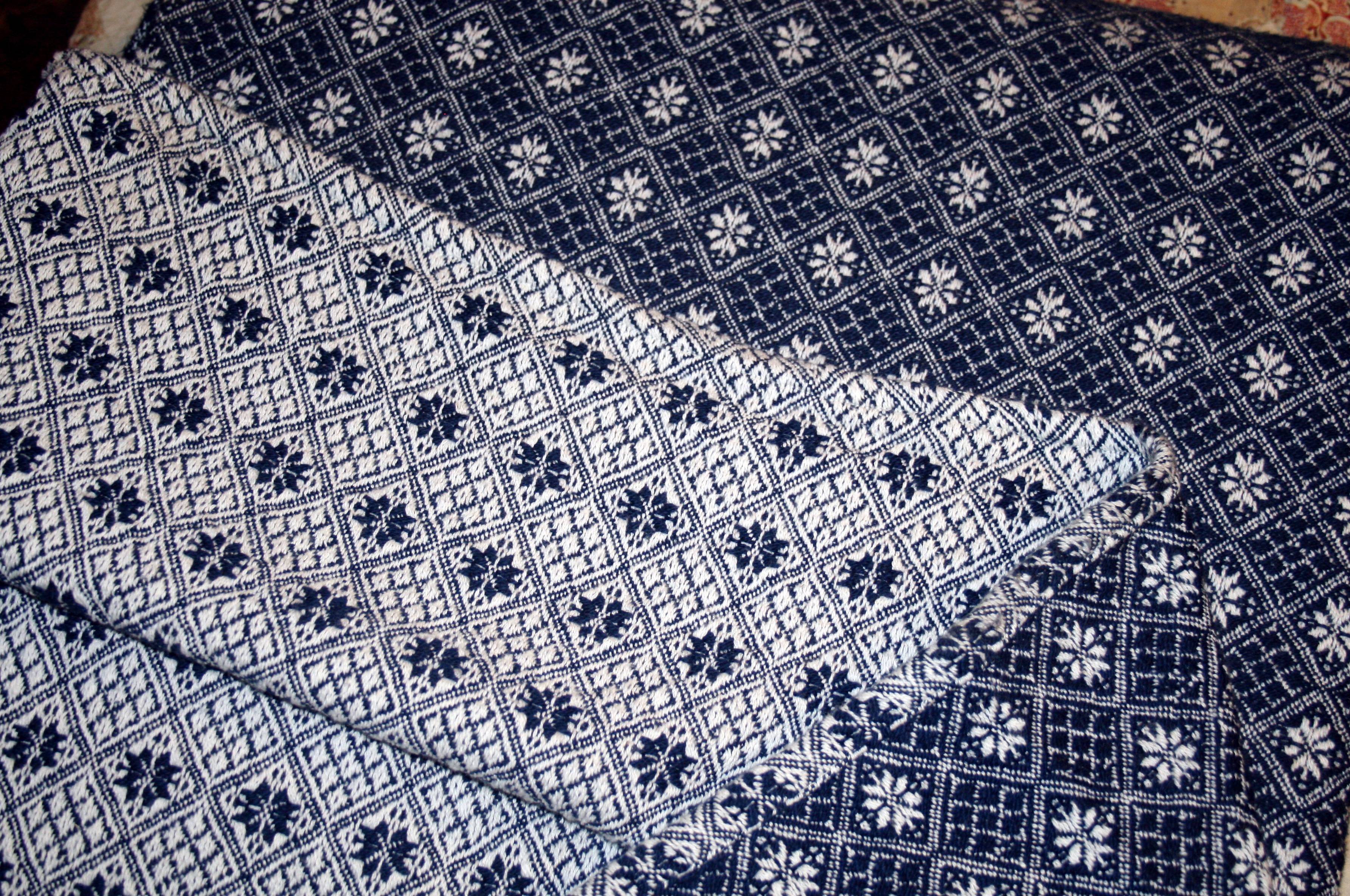 a woven coverlet in navy and white