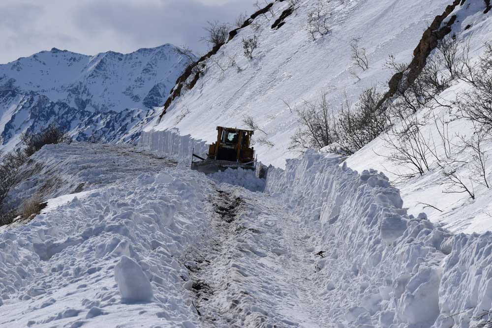 a machine plowing uphill through deep snow