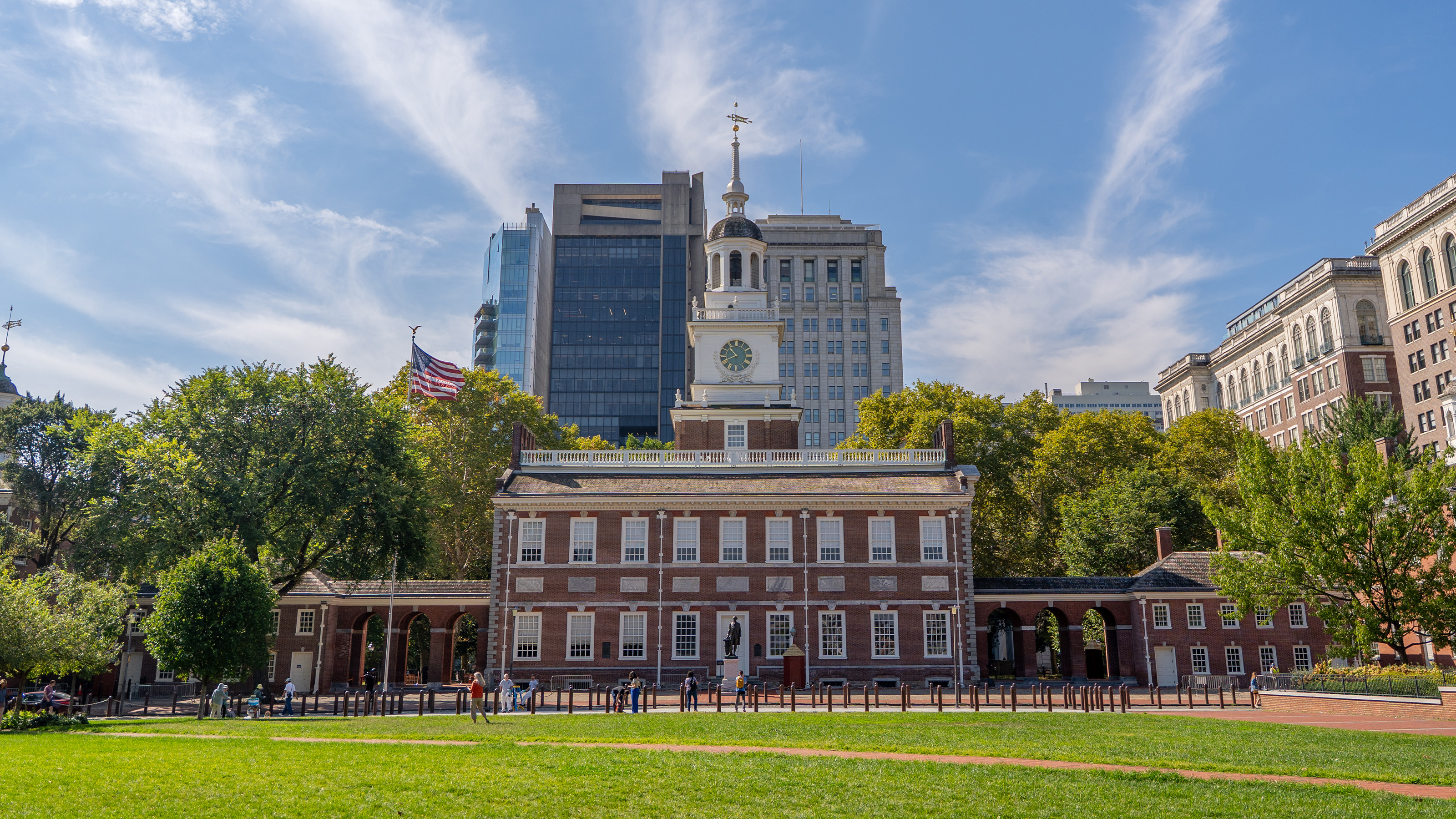 Color photo of Independence Hall, a large two story red brick building with central clock tower.
