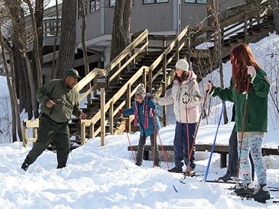 Ranger teaches children how to move on cross-country skis.