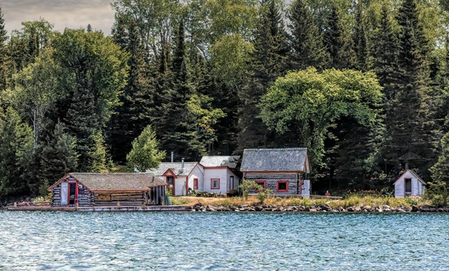 A view of Edisen Fishery from Lake Superior. The facilities include a dock, and several historic outbuildings.