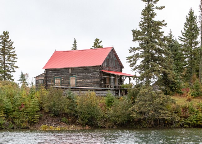 The historic log cabin style Johns Hotel with a new red roof.