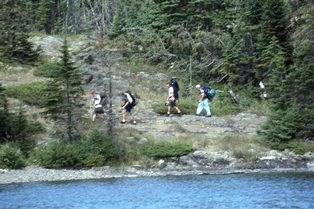 A group of backpackers hike the Rock Harbor Trail along Rock Harbor Channel
