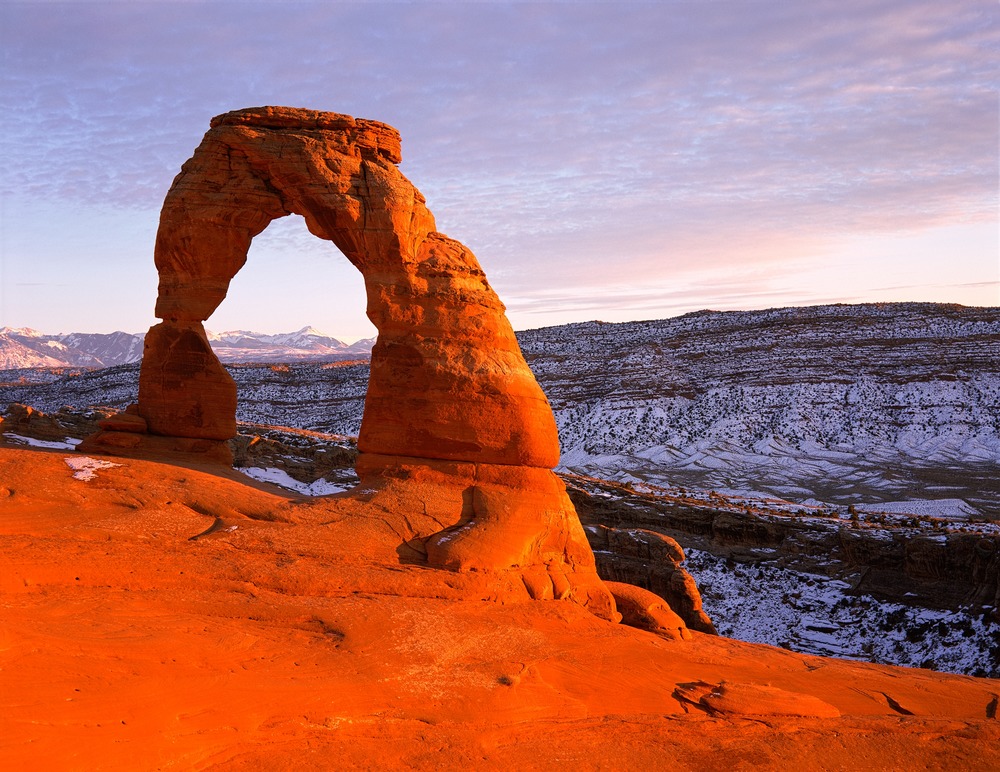 delicate arch An orange Arch amid a background of the sky and a hill