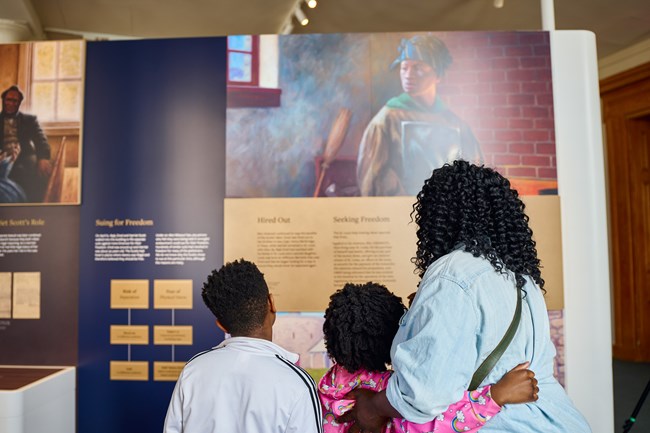 A family views museum exhibits about the Scotts
