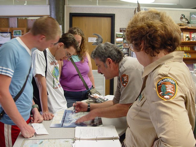 Volunteer, visitors and ranger at information desk