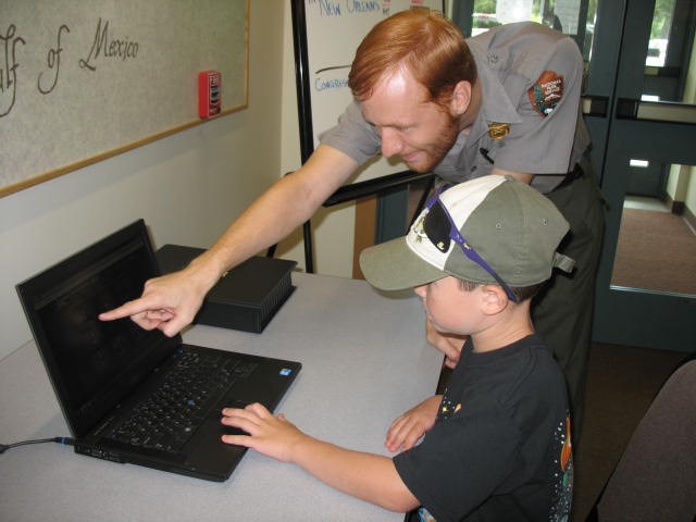 Image of ranger and young boy at computer