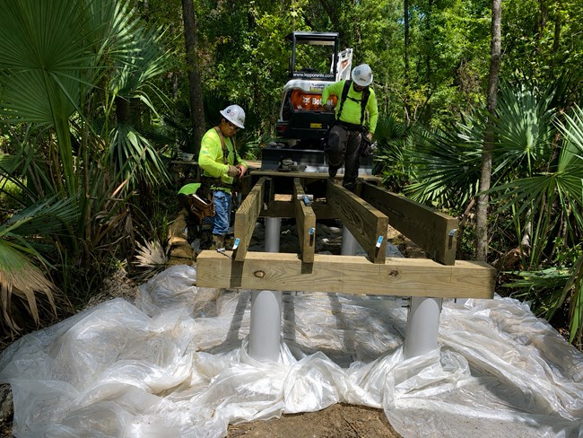 workmen building a new section of boardwalk in Barataria Preserve.