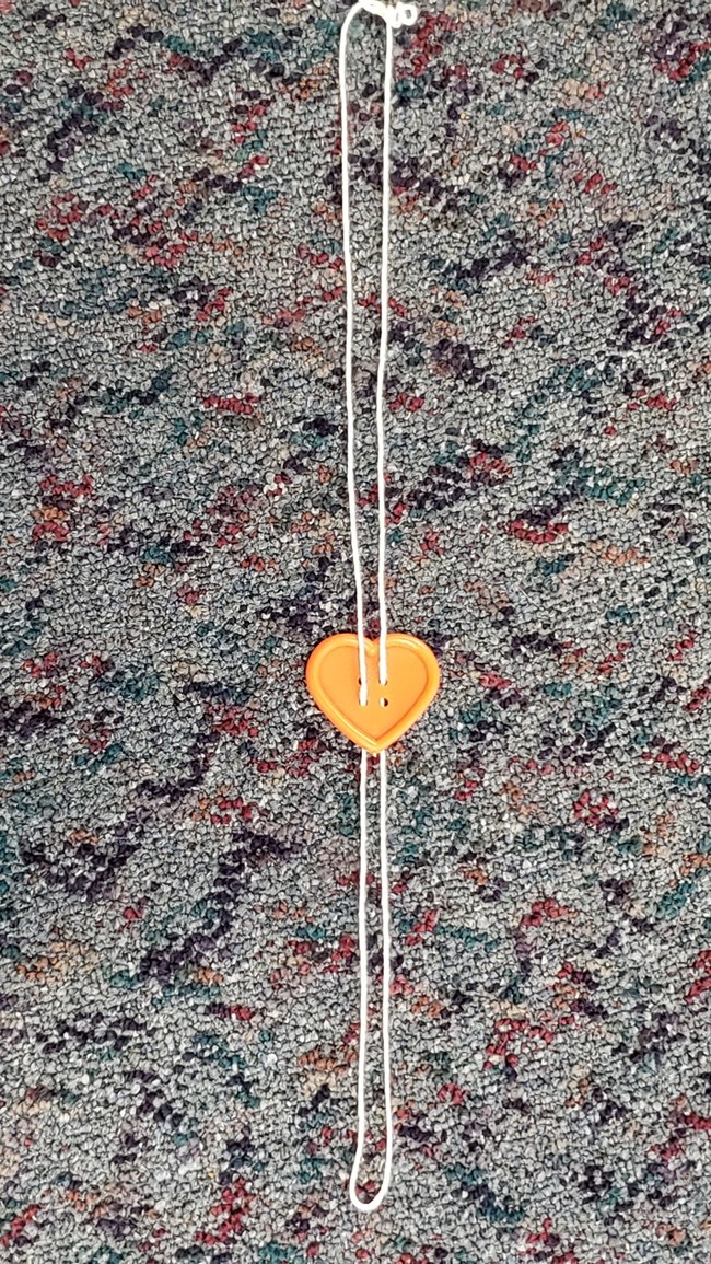 a heart button strung through with a piece of string