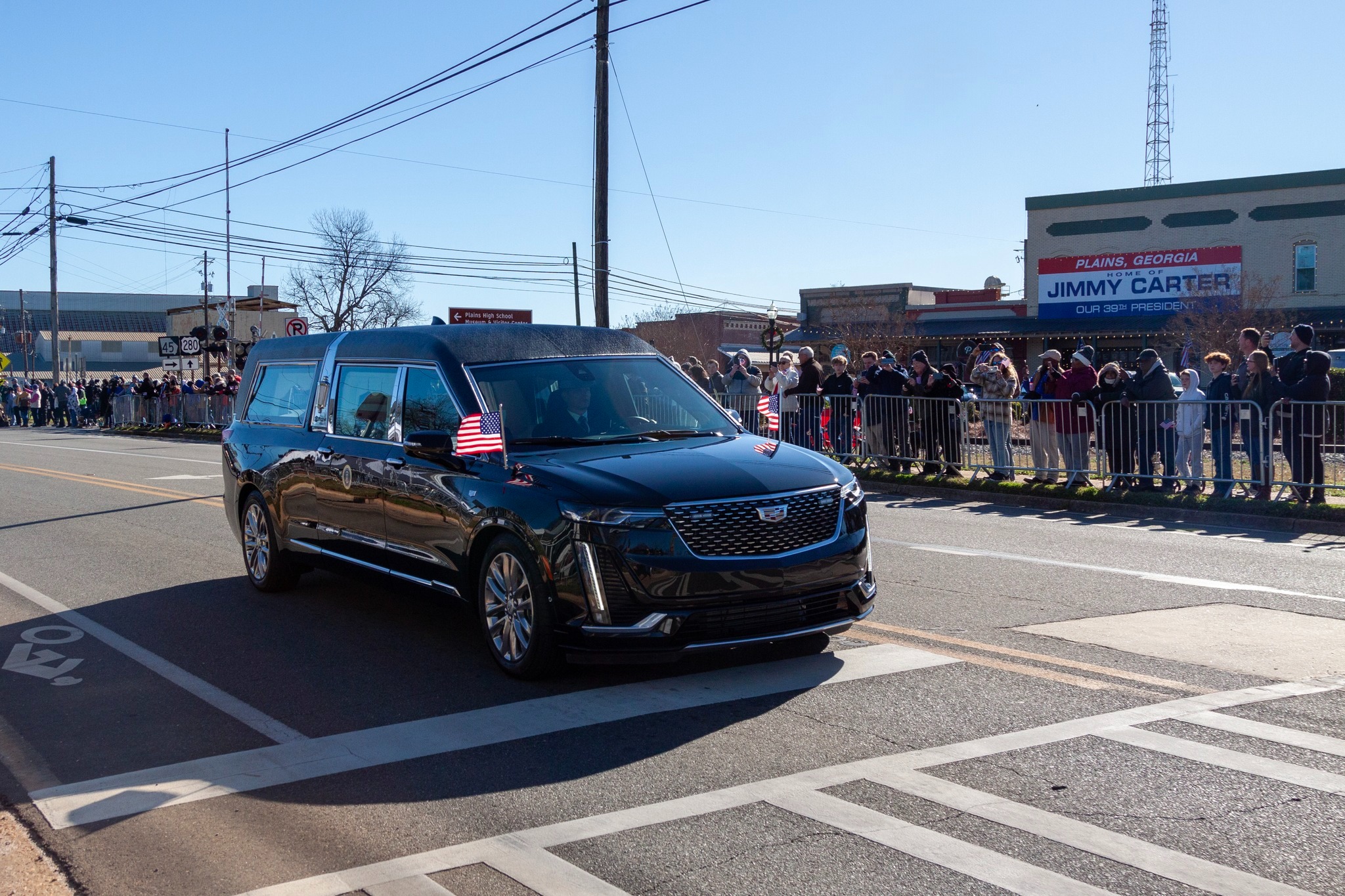 Hearse passing a crowd of people