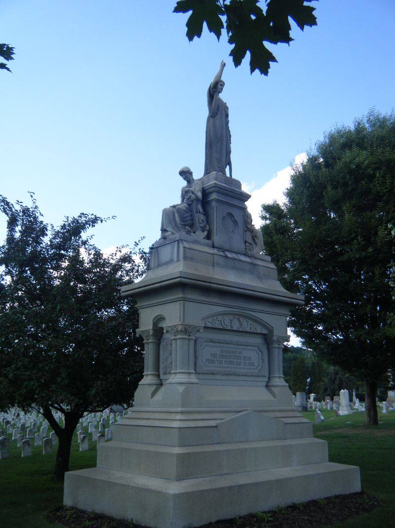 A monument with white headstones in the background.
