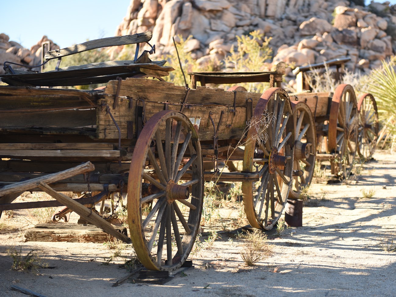Color photo of old-time wagon wheels in a line. NPS / Hannah Schwalbe