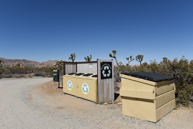 Two large dumpsters in a campground