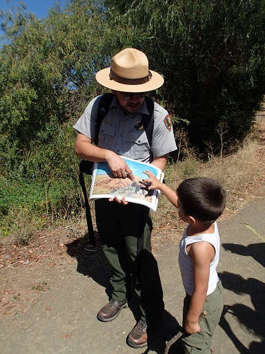 Park Ranger shows a young boy a photo book during a presentation. 