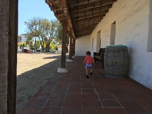 Young child walking down a hallway at a historic Mission. 