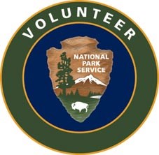 The NPS patch for Volunteers. Has an NPS shield in a circle logo, with the word "Volunteer" in an outside circle.
