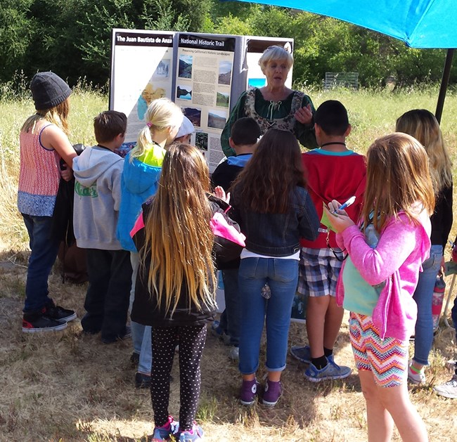 student writes notes at an Anza Trail station